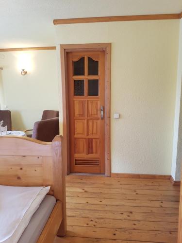 a bedroom with a wooden door and a room with a bed at Durda in Poronin