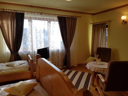 a bedroom with a bed and a window and a table at Durda in Poronin