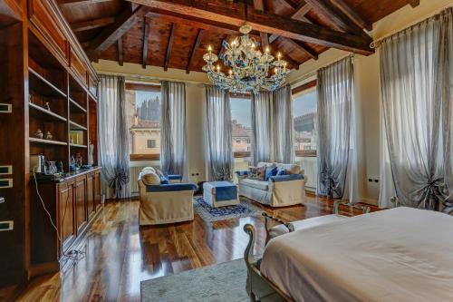 a bedroom with a bed and a chandelier at Relais Ponte Pietra in Verona