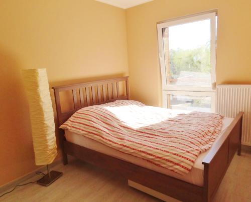 a small bedroom with a bed and a window at Apartment Panorama in Międzywodzie