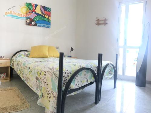 a bedroom with a bed with a comforter at Baia Verde Appartamenti Gallipolitravel in Gallipoli