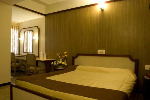 a bedroom with a bed and a table and a tableablish at Comfort Hotels in Coimbatore