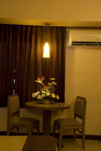 a room with a table and two chairs and a lamp at Comfort Hotels in Coimbatore