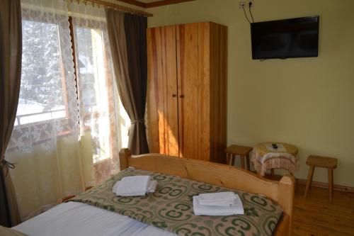 a bedroom with a bed and a tv and a window at Durda in Poronin