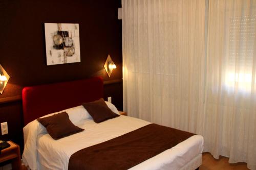a bedroom with a bed and a window at Hôtel Saint-Hubert in Saint-Claude