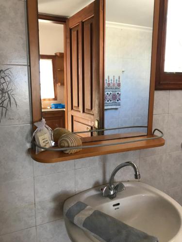 a bathroom with a sink and a mirror at Livadi center mountain view apartment in Livadi