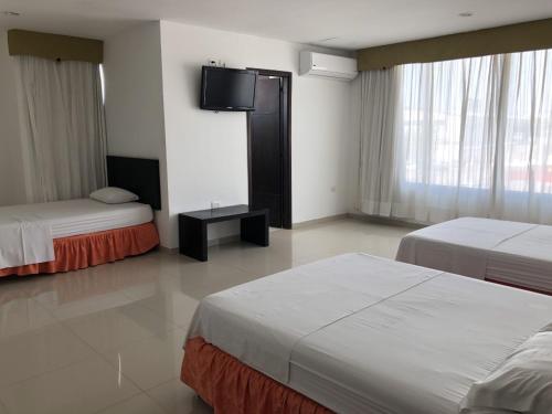 Habitación de hotel con 2 camas y TV de pantalla plana. en Hotel Via 40, en Barranquilla