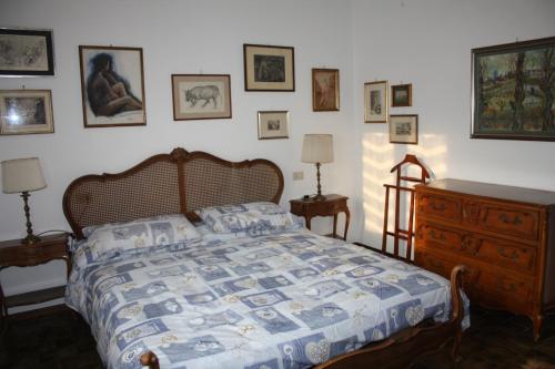 a bedroom with a bed and a dresser and pictures on the wall at Villa Anna in Sorico