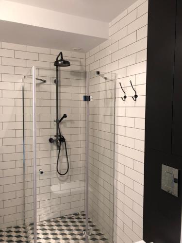 a shower in a bathroom with white tiles at the beskid view in Wisła