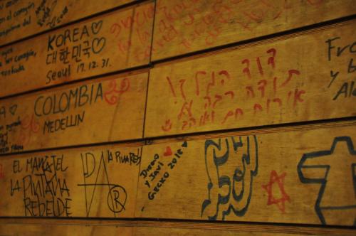 a wall covered in graffiti and writing on a wall at Gecko Hostel in Pucón