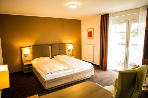 a hotel room with a bed and a window at Landgasthof "Zum grünen Walde" in Nordholz