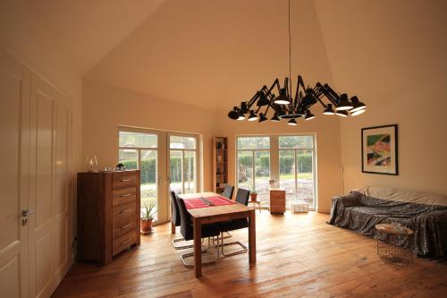 ein Wohnzimmer mit einem Tisch und ein Schlafzimmer in der Unterkunft Zur schönen Heide-Wabe in Egestorf