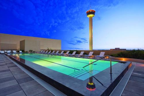 a swimming pool on the roof of a building with a tower at Grand Hyatt San Antonio River Walk in San Antonio