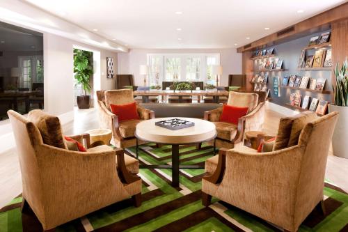 a living room with chairs and a table and a couch at Hyatt Regency Newport Beach in Newport Beach