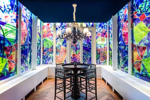a dining room with stained glass windows at Andaz Amsterdam, Prinsengracht, By Hyatt in Amsterdam
