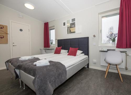 a bedroom with a large bed with red pillows at Hotell Eken Mölndal in Mölndal