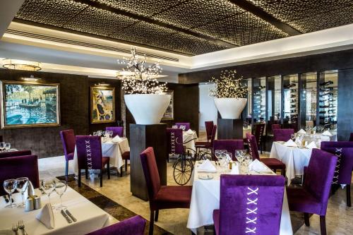 a restaurant with white tables and purple chairs at Hyatt Ziva Los Cabos - All Inclusive in San José del Cabo