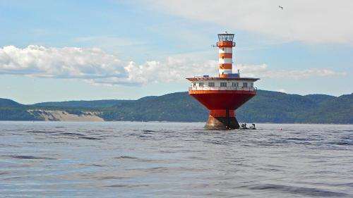 a lighthouse in the middle of a body of water at Le Ti Moose in La Malbaie