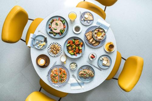 a table with plates of food on top of a teddy bear at Andaz Singapore, By Hyatt in Singapore