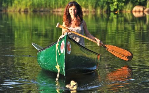 a woman is paddling a boat in the water at Le Ti Moose in La Malbaie