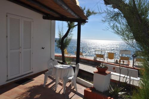 a patio with chairs and a table and a view of the ocean at La Citarea in Ischia