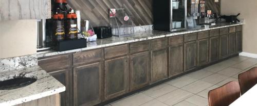 een keuken met houten kasten en een aanrechtblad bij Super 8 by Wyndham Jackson Ridgeland in Jackson