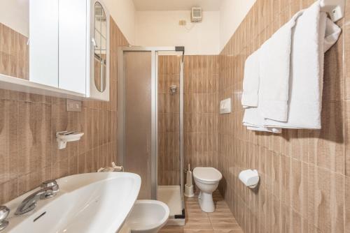 uma casa de banho com um chuveiro, um lavatório e um WC. em Albergo Cinzia em Vattaro