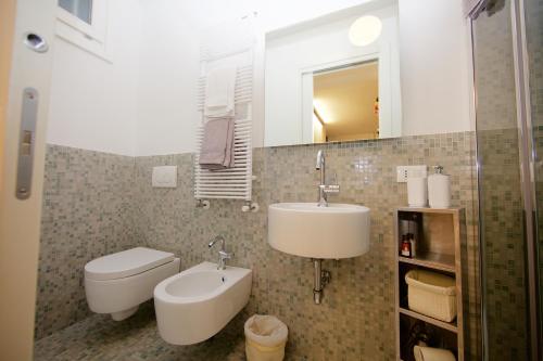 bagno con lavandino, servizi igienici e specchio di piccola corte a Venezia