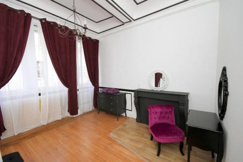Cette chambre comprend un bureau et une chaise violette. dans l'établissement Appartement Le roi, à Vesoul