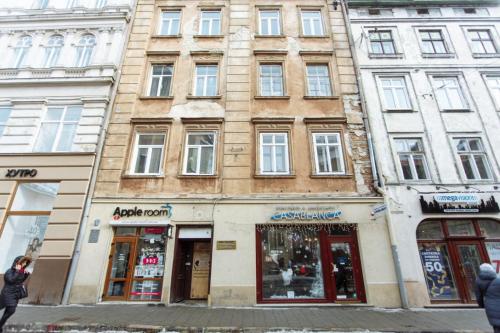 a tall building on a city street with stores at Halytska in Lviv