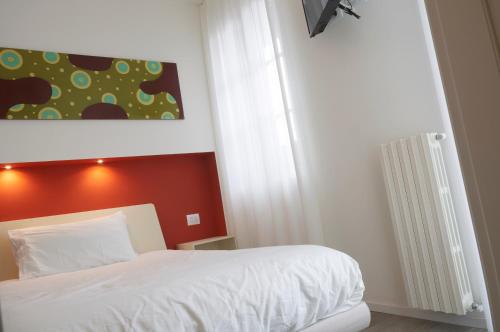 a bedroom with a white bed and a painting on the wall at VILLA FENIX OSIO SOTTO in Osio Sotto