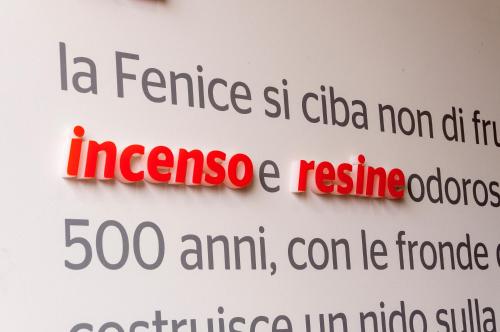 a sign with red and black writing on a wall at VILLA FENIX OSIO SOTTO in Osio Sotto