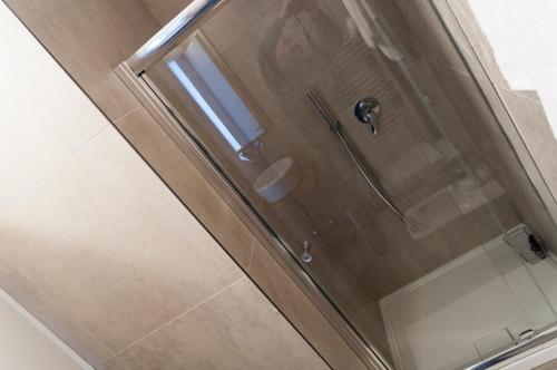 a shower stall with a glass door with a shower at VILLA FENIX OSIO SOTTO in Osio Sotto