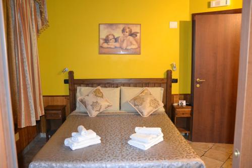 1 dormitorio con 1 cama con toallas en EneaHouse, en Fiumicino
