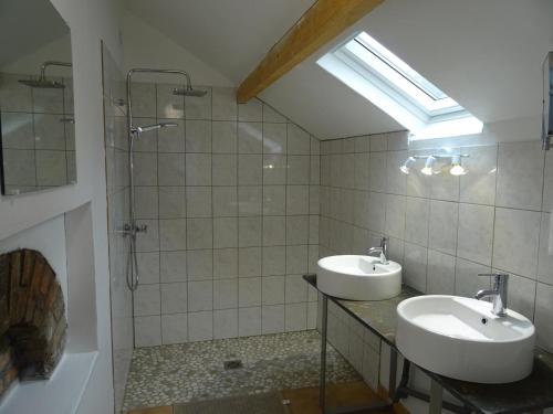 a bathroom with two sinks and a shower at Gîte de La Ronce in Dhuizon