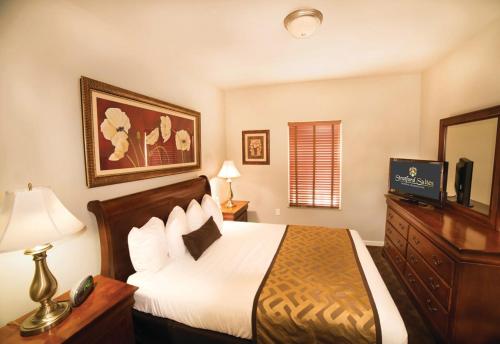 a bedroom with a bed and a tv on a dresser at Stratford Suites Spokane Airport in Airway Heights