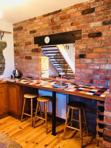 a kitchen with a brick wall and a counter with stools at Spindrift in Moville