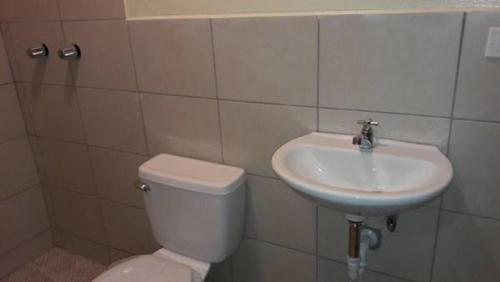 a bathroom with a toilet and a sink at Airport Inn Managua in Managua
