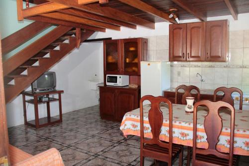 a kitchen with a table with chairs and a kitchen with a microwave at Residencial Aracuã in Bombinhas