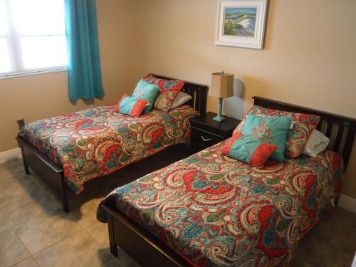 a bedroom with two beds and a window and a bed sidx sidx sidx at Spanish Main in Cocoa Beach