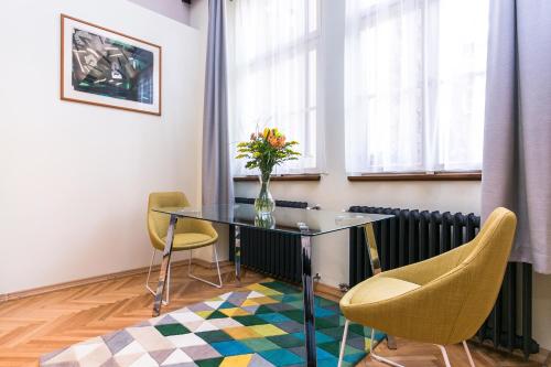 a dining room with a glass table and chairs at Apartment Nebovidy I - Historic centre - Terrace - Air Conditioning in Prague
