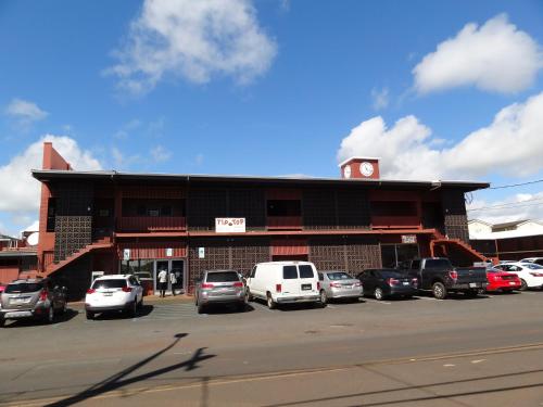 a building with cars parked in a parking lot at Tip Top Motel in Lihue