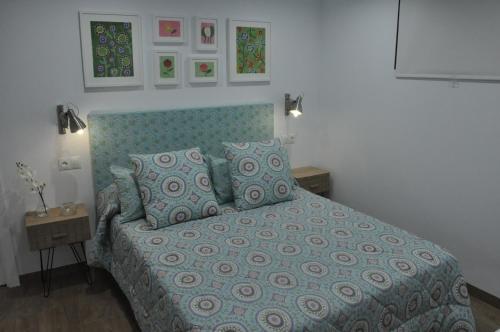 a bedroom with a bed with a blue comforter and pillows at La Casita De Angela in Frigiliana