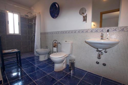W łazience znajduje się umywalka, toaleta i umywalka. w obiekcie Finca el Rabilargo w mieście Arroyomolinos de Montánchez