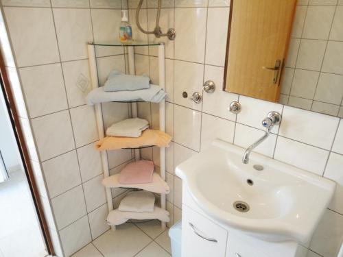a bathroom with a sink and a shower with towels at Apartment Marina in Marina