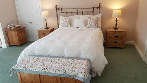 a bedroom with a large bed and two night stands at The Old Cottage in Arduaine