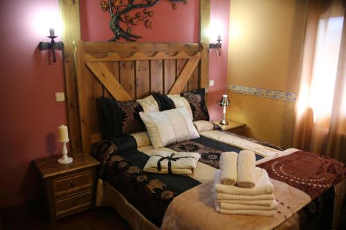a bedroom with a bed with towels on it at Apartamentos Rurales "La Cabaña" in Rascafría