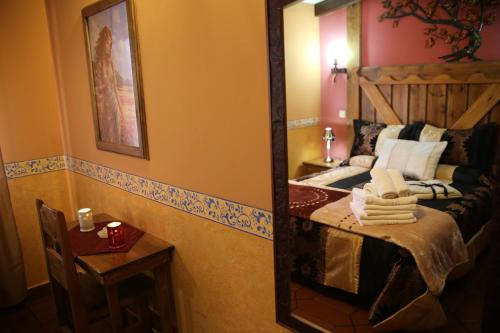 a mirror in a room with a bed and a table at Apartamentos Rurales "La Cabaña" in Rascafría