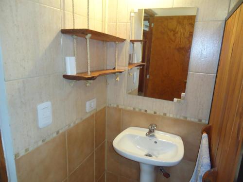y baño con lavabo y espejo. en Cabañas Peñi Huen en Lago Puelo