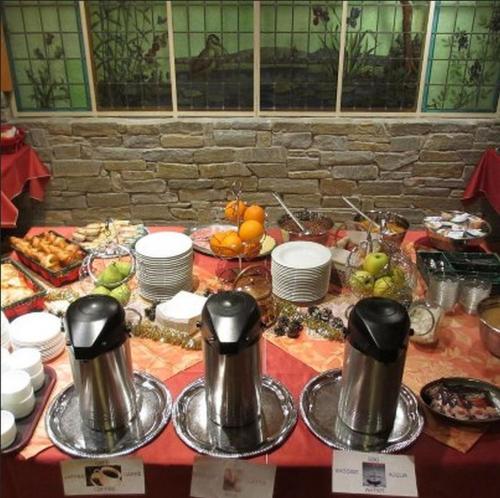 ブリッド・レ・バンにあるホテル レ シャレーのビュッフェ形式の食べ物と鍋やフライパンが置かれたテーブル